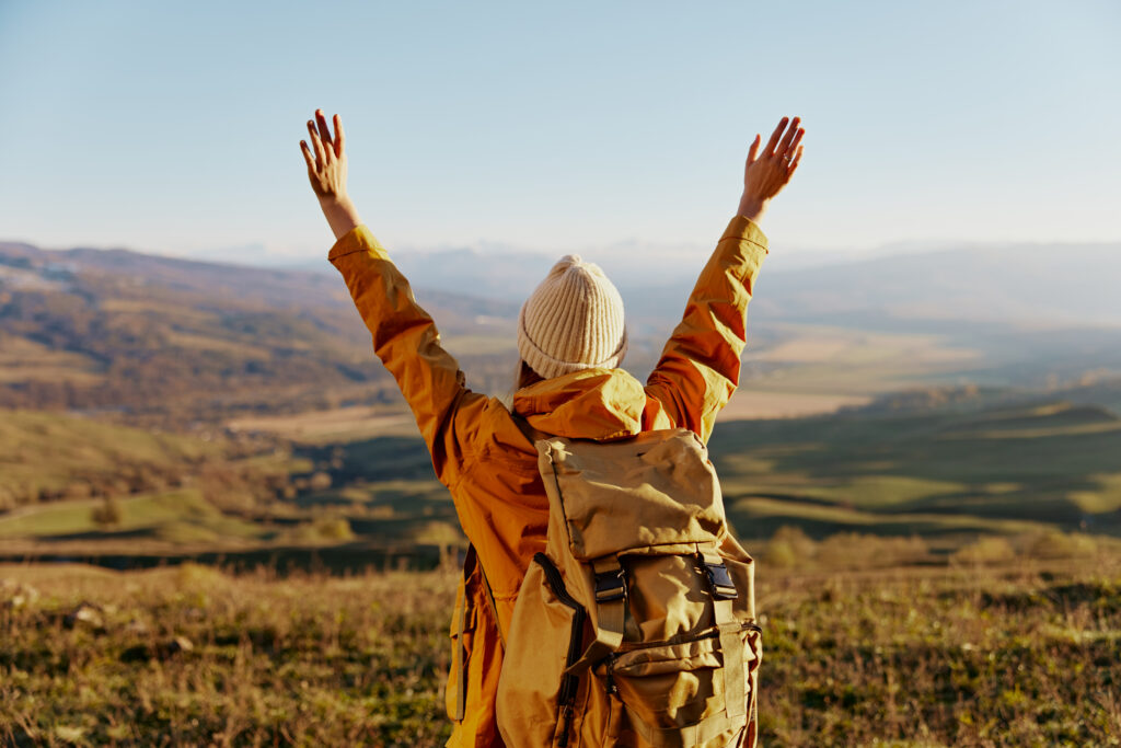 woman traveler in a yellow jacket in a hat backpack travel mountains Lifestyle